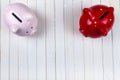 Two pigs piggy banks on a white wooden background