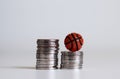 Two pile of coins and a miniature basketball.