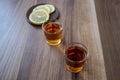 Two piles of whiskey and slices of lemon on a wooden background Royalty Free Stock Photo