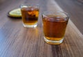 A two piles of whiskey and slices of lemon on a wooden background Royalty Free Stock Photo