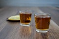 A two piles of whiskey and slices of lemon on a wooden background Royalty Free Stock Photo