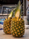 Two pinacolada coctails in fresh pineapple fruit on the beachbar table. Royalty Free Stock Photo