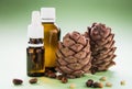 two pine cones with pine nuts and glass bottles on a green background, close-up Royalty Free Stock Photo