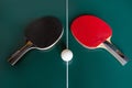 Two ping-pong rackets and a ball on a green table Royalty Free Stock Photo