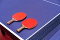 Two pingpong table tennis rackets for playing are laid on next to net on the blue table. This is one of ping pong sports equipment Royalty Free Stock Photo