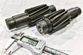Two pinion shafts with a spiral tooth and an electronic vernier caliper on a technical card Royalty Free Stock Photo