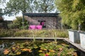 Two pink chairs under an overhang for a pond to enjoy the sun in