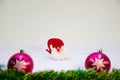 Two pink christmas balls,red hat toy Santa and Christmas decoration on a white background