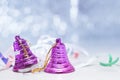 Two pink Christmas bells on a table with festive tinsel on a blue bokeh background Royalty Free Stock Photo