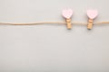 Two pink clothespins hearts hanging on rope on grey background Royalty Free Stock Photo