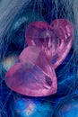 Two pink crystal heart shapes on blue glasses Royalty Free Stock Photo