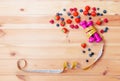 Two pink dumbbells, measuring tape and berries on wooden background Royalty Free Stock Photo