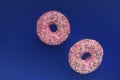 Two pink glazed donuts colorful sprinlkes floating