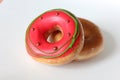 Two pink glazed Donuts covered with sugar crumbs in white background isolated close-up. Valentine's donuts. top view Royalty Free Stock Photo