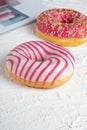 Two pink glazed Donuts covered with sugar crumbs in white background isolated close-up. Valentine's donuts. top view Royalty Free Stock Photo