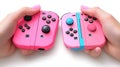 Two pink handheld gaming controllers held by hands Royalty Free Stock Photo