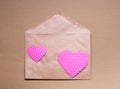 Two pink hearts on craft paper envelop