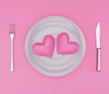 Two pink hearts on plate, knife and fork Royalty Free Stock Photo