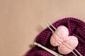 Two pink knitting yarn balls, knitting needles and and purple knitted plaid top view Royalty Free Stock Photo