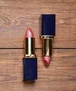 Two pink lipsticks on a wooden table. Top view Royalty Free Stock Photo