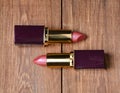 Two pink lipsticks on a wooden table. Top view Royalty Free Stock Photo