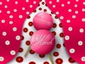 Two pink lollipops form the figure eight on a colorful background with flowers.