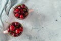 Two pink mugs with fresh ripe cherries. Sweet organic berries on a light concrete background. Top view with copy space Royalty Free Stock Photo