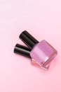 Two pink nail polish bottles on pink background. Two pink nail polish bottle one on top of another. Copy space Royalty Free Stock Photo