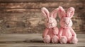 Two pink plush rabbits on rustic wooden background. Easter and springtime decoration concept Royalty Free Stock Photo