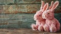 Two pink plush rabbits on rustic wooden background. Easter and springtime decoration concept Royalty Free Stock Photo