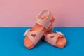 Two pink sandals on pink, blue background. Cute pink sandals for little girl