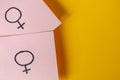 Two pink stickers with the gender symbols Venus above yellow background. Concept lgbt