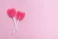 Two Pink Valentine`s day heart shape lollipop candy on empty pastel pink paper background. Love Concept. top view.