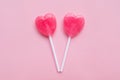 Two Pink Valentine`s day heart shape lollipop candy on empty pink paper background. hipster Minimal Love Concept. top view. Royalty Free Stock Photo