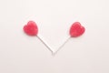 Two Pink Valentine`s day heart shape lollipop candy on empty white paper background. hipster Minimal Love Concept. top view. Royalty Free Stock Photo