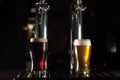 Two pint glasses of beer, a golden one and a dark one on the bar tab. Royalty Free Stock Photo