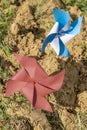 Two pinwheels, one red and the other white and blue, are stuck in clods of freshly plowed earth Royalty Free Stock Photo