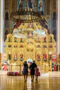 Two pious women with their children have come to St. Ekaterina Orthodox Cathedral to pray and worship. Vertical inside view