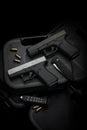 Two pistols, 9mm cartridges and a penknife lie on a plastic gun case. Self-defense and survival kit. Compact edged weapons and