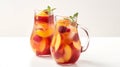Two pitchers of refreshing fruit-infused water with peach slices and berries, garnished with mint