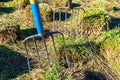 Two pitchforks stuck in the grass covered ground Royalty Free Stock Photo