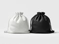 Two plain drawstring bags made of soft material standing side by side in contrasting black and white colors on a simple white Royalty Free Stock Photo