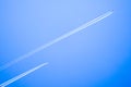 Two planes flying high in the sky, leaving white streaks Royalty Free Stock Photo