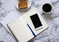 Two planners on marble background, coffee, waffles and smartphone