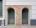 Two plastic arched windows in a brick wall of an old restored ho