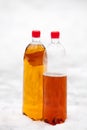 Two plastic beer one litre bottles full and half with red caps o Royalty Free Stock Photo