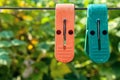 Two Plastic Clothespins on Clothes Line on Blurred Green Leaves Background on a Sunny Summer Day Royalty Free Stock Photo