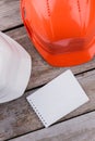 Two plastic constructor workers helmets and notepad for copy space. Royalty Free Stock Photo