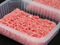 Two plastic containers with minced pork and beef in them lying on a black mat Royalty Free Stock Photo