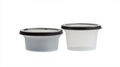 Two plastic containers, one is black and the other is white Royalty Free Stock Photo